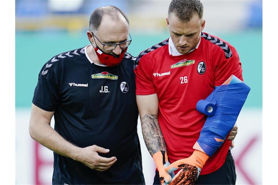 Schwerer Rückschlag für Freiburgs Flekken: Uphoff im Fokus Freiburgs Torwart Mark Flekken geht vor Spielbeginn verletzt vom Spielfeld. Foto: Uwe Anspach/dpa/Aktuell