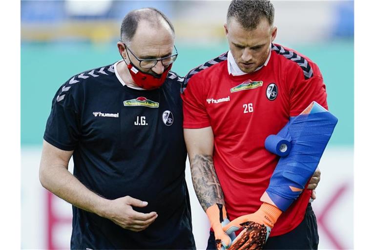 Freiburgs Torwart Mark Flekken geht vor Spielbeginn verletzt vom Spielfeld. Foto: Uwe Anspach/dpa/Aktuell