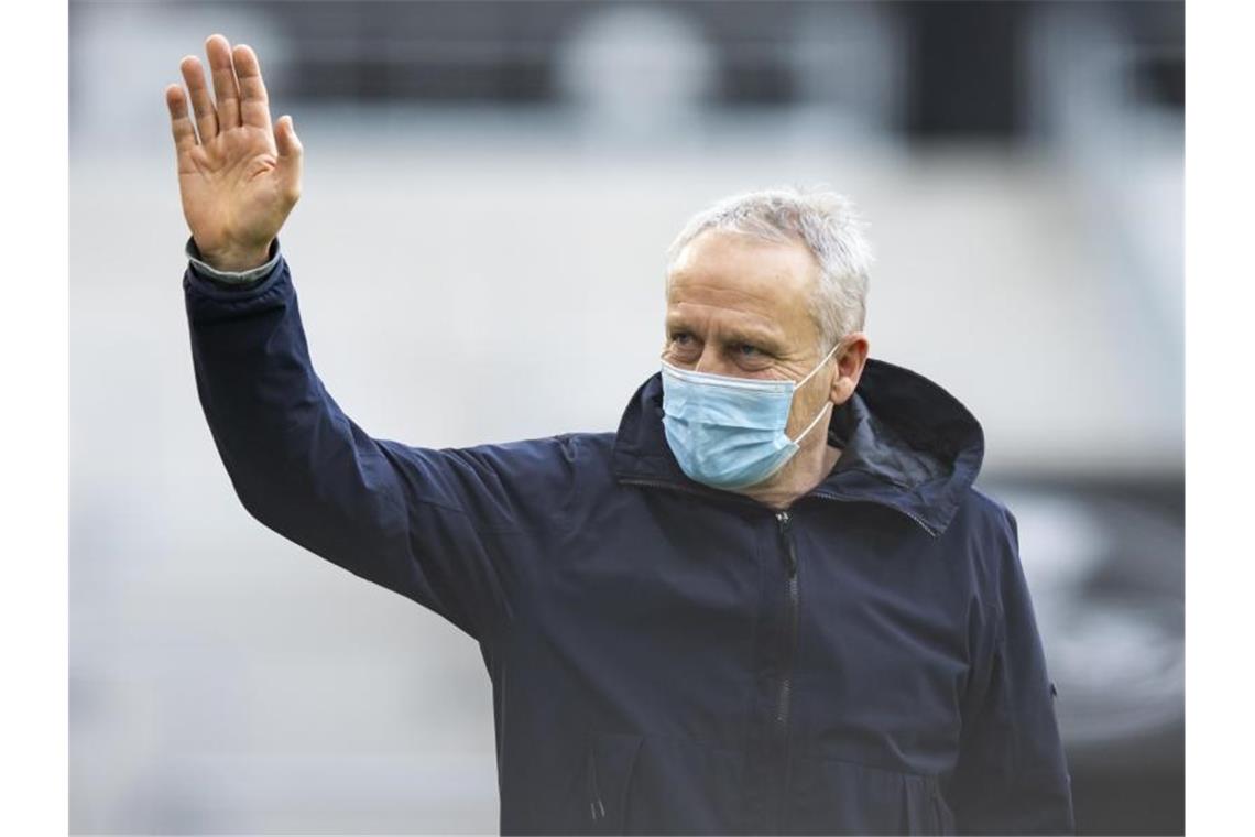 Freiburgs Trainer Streich will keine Meister-Playoffs Freiburgs Trainer Christian Streich steht vor einem Spiel im Stadion und winkt. Foto: Tom Weller/dpa
