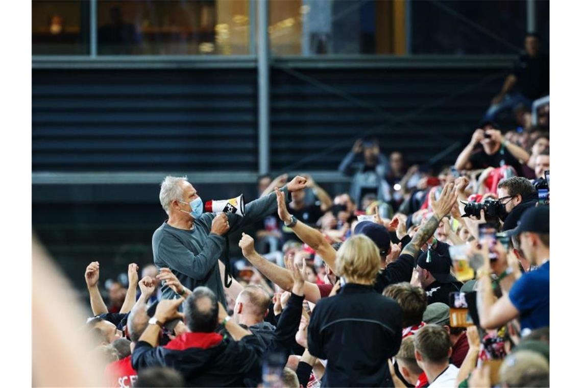 Freiburgs Trainer Christian Streich verabschiedet sich nach dem 3:0-Erfolg gemeinsam mit den Fans vom altehrwürdigen Dreisamstadion. Foto: Philipp von Ditfurth/dpa