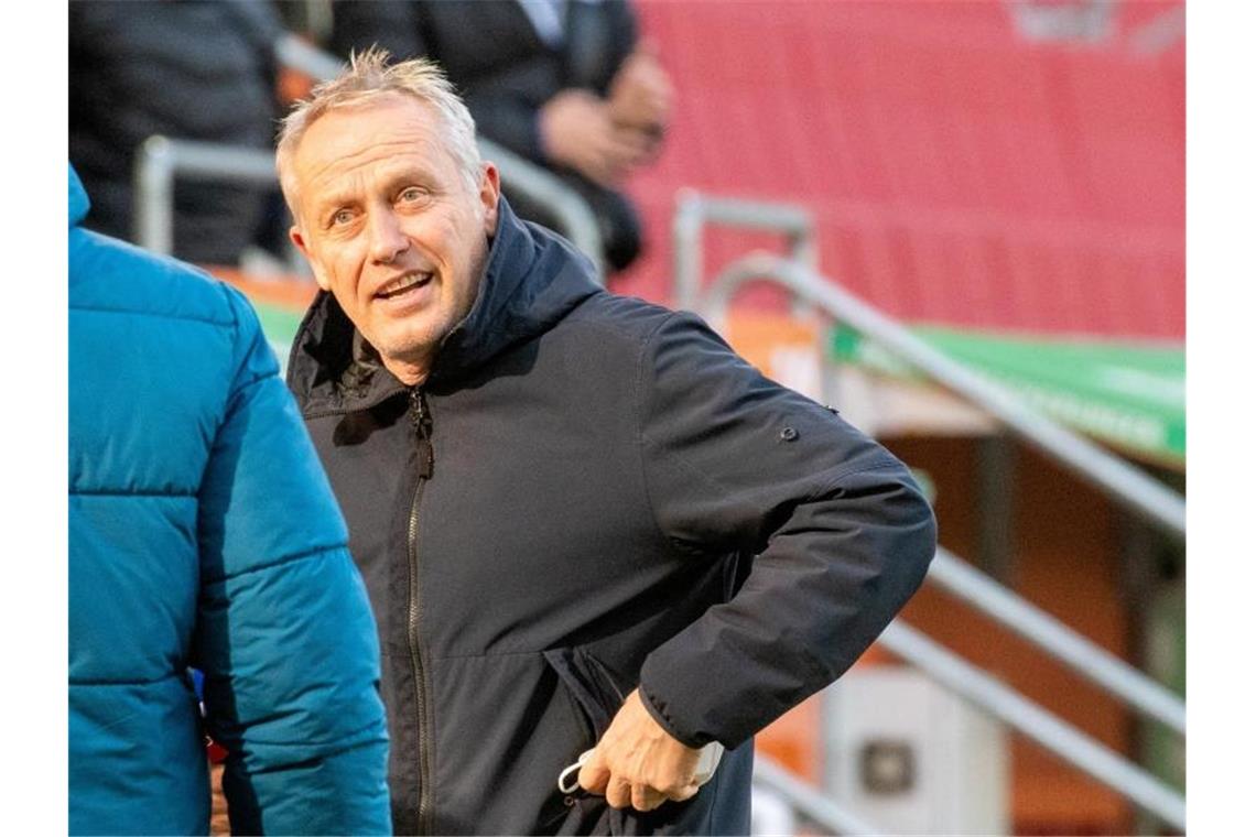 Streich froh für SC-Profi Schmid: „Er hatte schwer Corona“ Freiburgs Trainer Christian Streich verstaut seine Atemmaske. Foto: Stefan Puchner/dpa