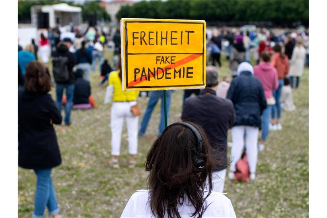 "Freiheit/Fake-Pandemie": Eine Teilnehmerin einer Demonstration mit einem Protestschild in München. Foto: Sven Hoppe/dpa