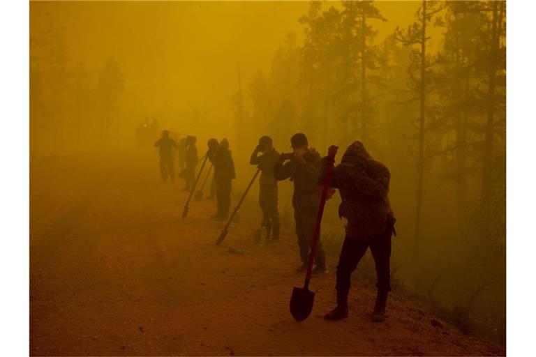 Freiwillige Helfer machen am Ort eines Waldbrands im Gebiet Gorny Ulus westlich von Jakutsk eine Pause. Foto: Ivan Nikiforov/AP/dpa