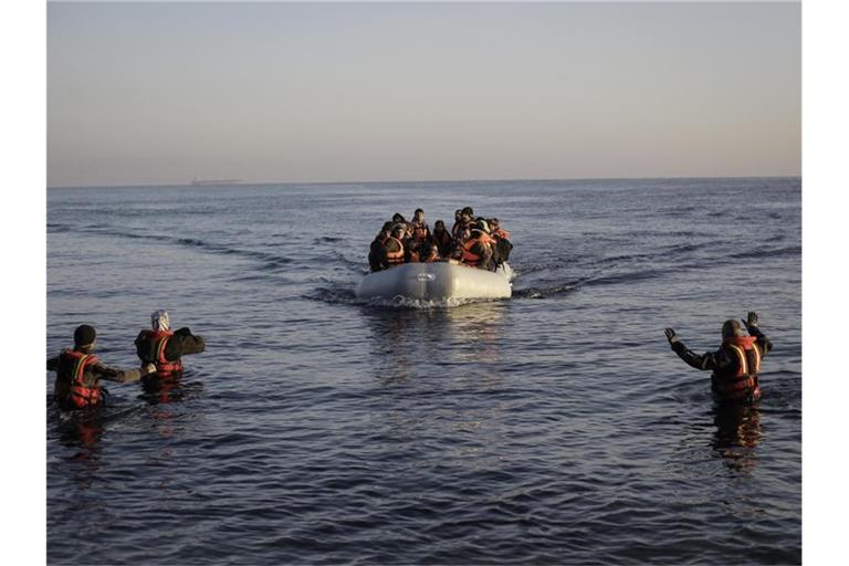 Freiwillige Helfer nehmen auf der griechischen Lesbos ein kaum seetüchtiges Gummiboot mit Flüchtlingen aus der Türkei in Empfang. Foto: picture alliance/Socrates Baltagiannis/dpa/dpa