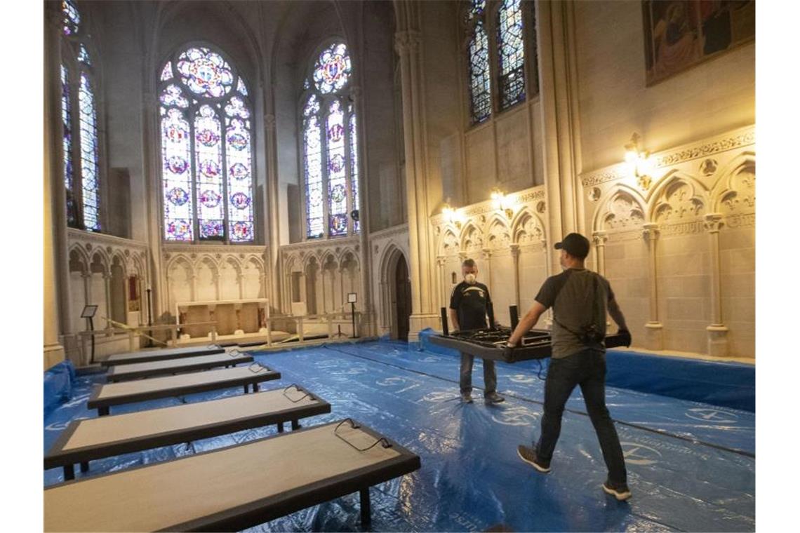 Zweiter Tag in Folge mit fast 2000 Corona-Toten in den USA Freiwillige Helfer stellen in der Kathedrale St. John the Divine in New York Betten für Corona-Patienten auf. Foto: Mary Altaffer/AP/dpa