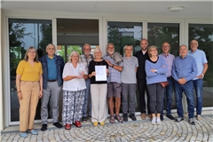 Freuen sich über die KfW-Urkunde (von links): Brigitte und Hans-Martin Trein, Marlis Schramm, Helmut und Hannelore Belznder, Heinz Goeckler, Wolfgang Kurr, die Architekten Jan Escher und Ursula Steinhilber, Bernd Claus, Michael Matzke und Gerhard Schramm. Foto: privat
