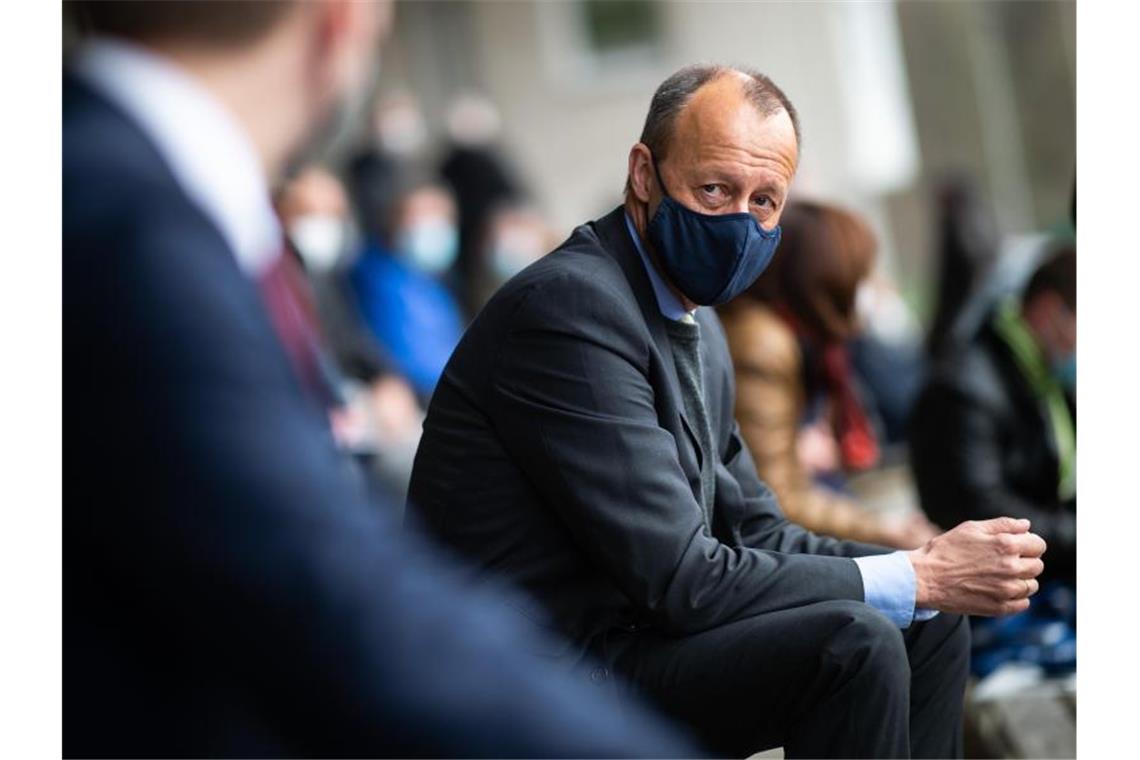 Friedrich Merz (CDU), ehemaliger Vorsitzender der Unions-Fraktion im Bundestag, sitzt auf der Tribüne des Stadions Große Wiese. Foto: Jonas Güttler/dpa