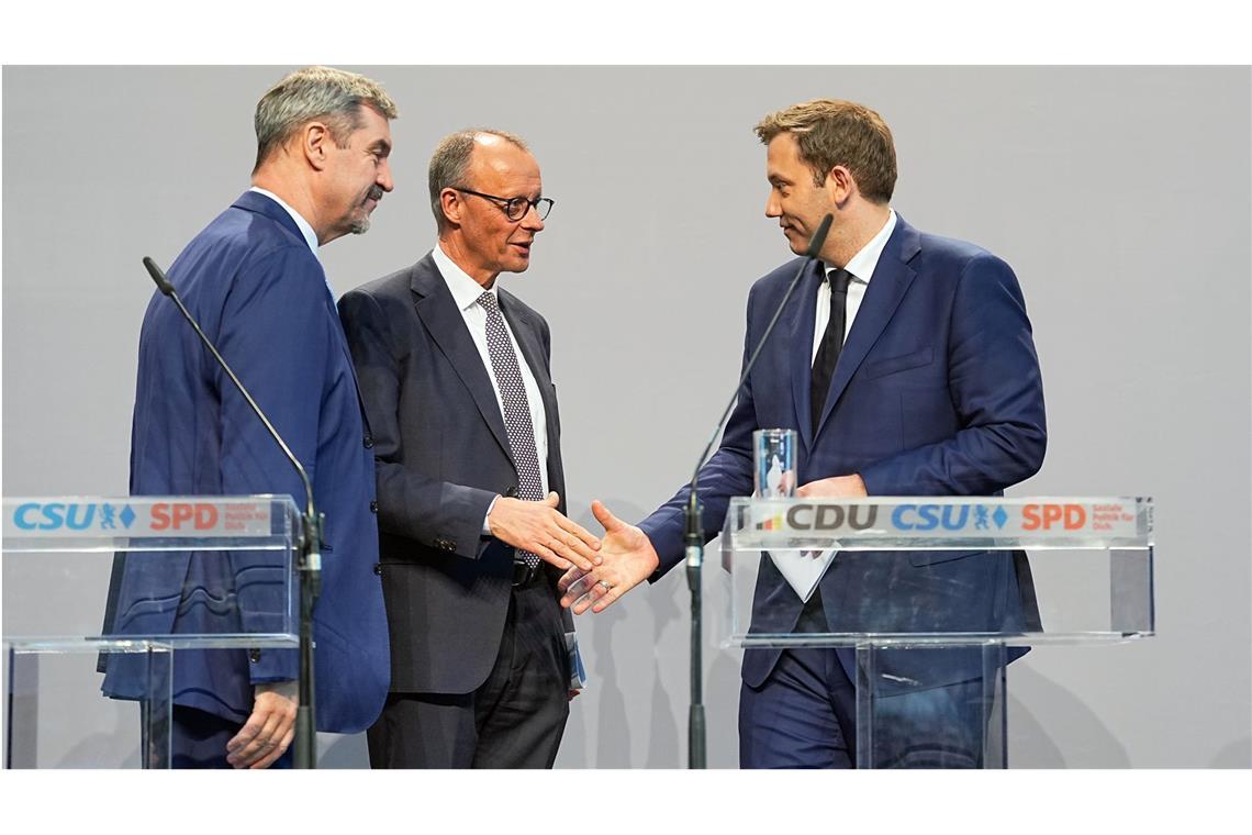 Was Schwarz-Rot wann plant Friedrich Merz (CDU, Mi.) und Lars Klingbeil (SPD, re.), geben sich nach einer Pressekonferenz zur Vorstellung des Koalitionsvertrages die Hand. Links steht Markus Söder, Ministerpräsident von Bayern und CSU-Vorsitzender.