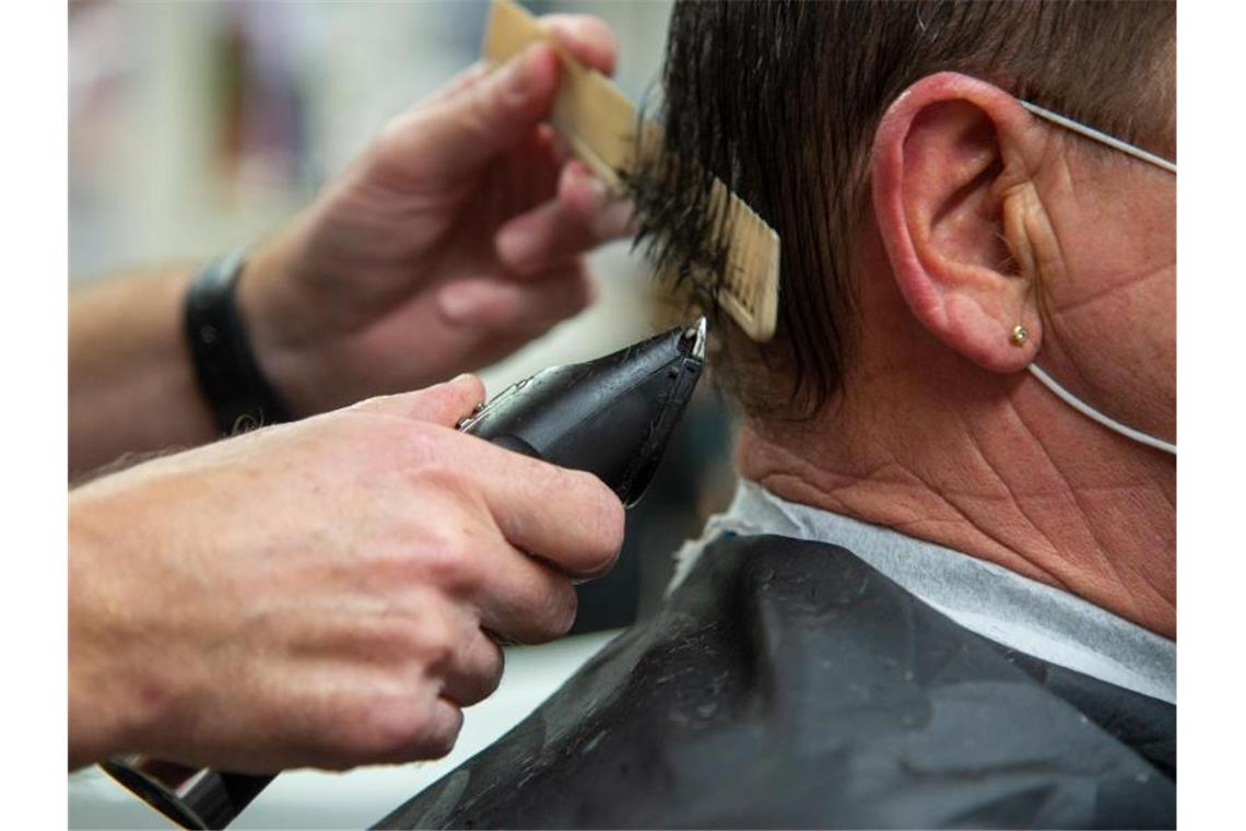 Großer Ansturm auf Friseursalons Friseur Guido Wirtz schneidet einem Kunden die Haare. Der Vorsitzende Landesinnungsmeister beim Landesverband Friseure und Kosmetik Rheinland hat vor dem zweiten Lockdown noch alle Hände voll zu tun. Foto: Harald Tittel/dpa