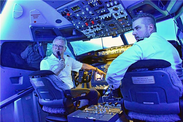 Fritz Klaiber (links) erklärt im Flugsimulator, wie ein Flug abläuft und welche technischen Geräte im Cockpit für Sicherheit sorgen. Foto: Tobias Sellmaier