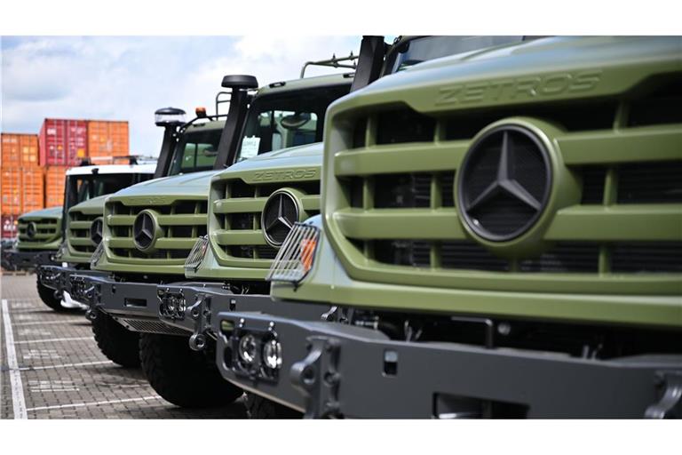 Für das Militär ausgestattete Laster vom Typ Zetros stehen vor einer Produktionshalle eines Lkw-Montagewerks von Mercedes-Benz Trucks.