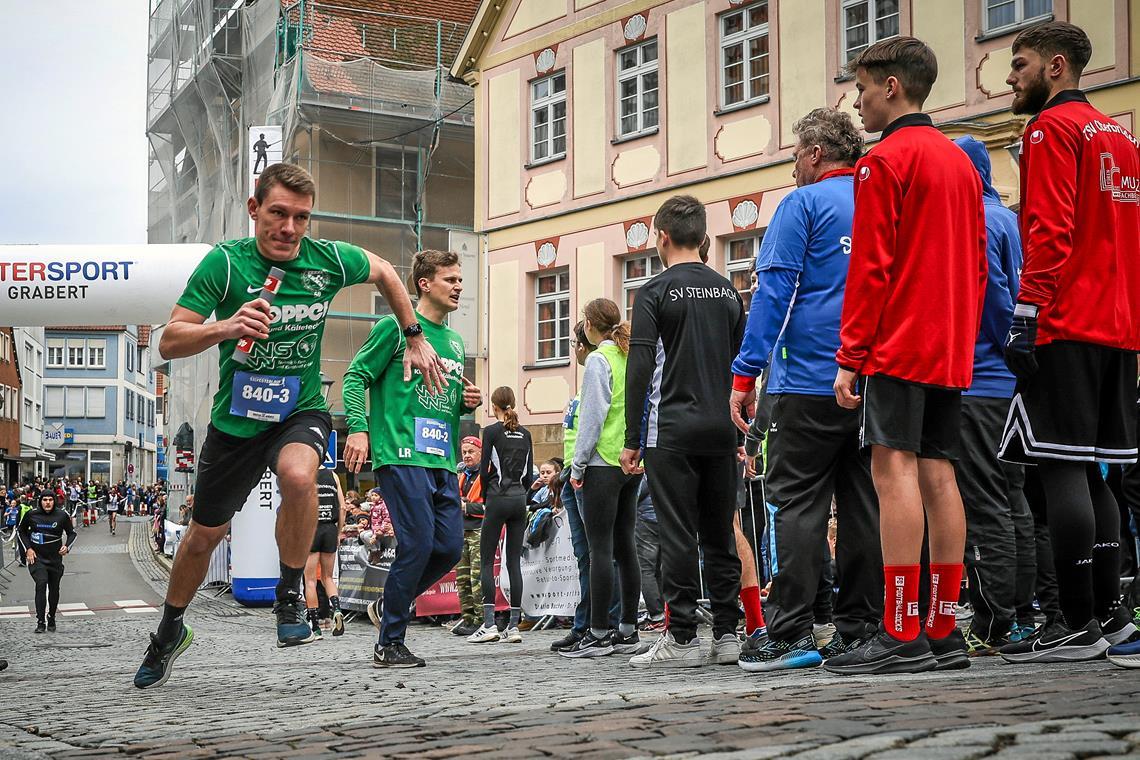 36. Backnanger Silvesterlauf: Der Spaß steht über dem sportlichen Erfolg Für die Fußballer der SG Oppenweiler-Strümpfelbach übernimmt Marcel Friz das Staffelholz von Lukas Rosenke und sprintet mit einem Affenzahn los. Foto: Alexander Becher