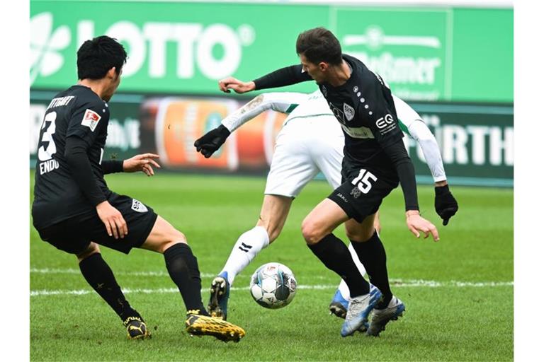 Fürths Branimir Hrgota (M) kämpft mit Stuttgarts Pascal Stenzel (r) und Wataru Endo (l) um den Ball. Foto: Nicolas Armer/dpa