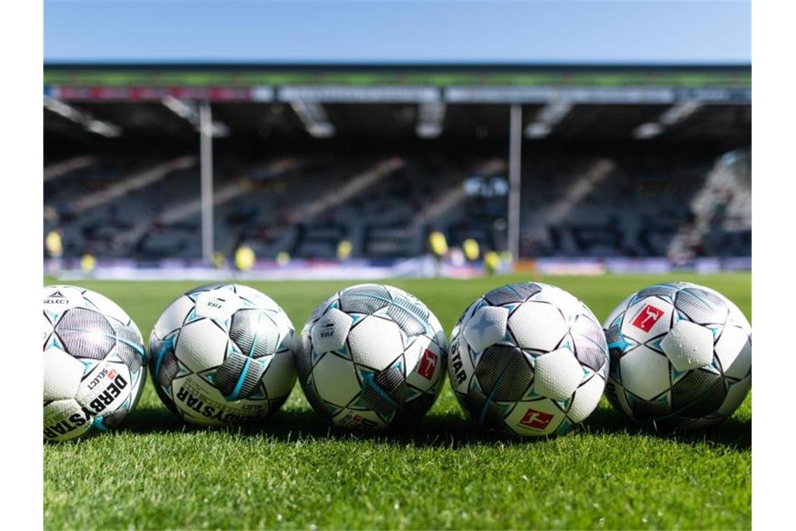 SC Freiburg plant Heim-Auftakt mit bis zu 3200 Fans Fußbälle liegen vor der Tribüne im Schwarzwaldstadion auf dem Rasen. Foto: Patrick Seeger/dpa/Archivbild