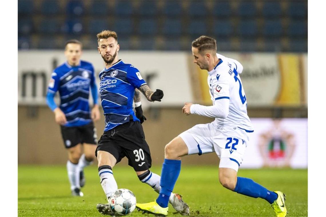 Fußball: 2. Bundesliga, Arminia Bielefeld - Karlsruher SC, 16. Spieltag, in der Schüco-Arena. Bielefelds Marcel Hartel (l) und Karlsruhes Christoph Kobald kämpfen um den Ball. Foto: David Inderlied/dpa