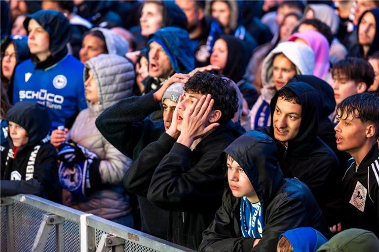 Fußball-Fans reagieren mit Entsetzen und Fassungslosigkeit auf die Tore der gegnerischen Mannschaft.
