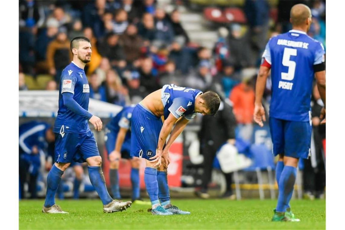 Fußballspieler des Karlsruher SC beim Spiel gegen Holstein Kiel. Foto: Tom Weller/dpa