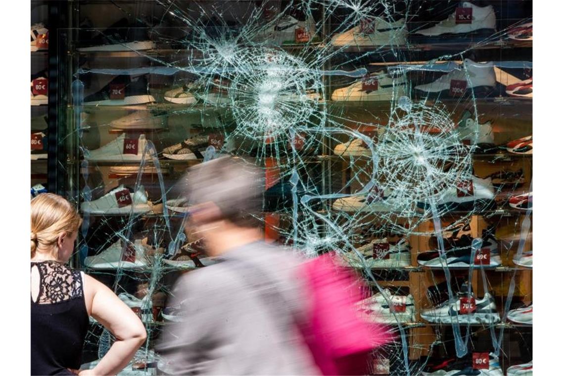 Fußgänger gehen an einem schwer beschädigten Schaufenster in der Königstraße vorbei. Foto: Christoph Schmidt/dpa/Archivbild