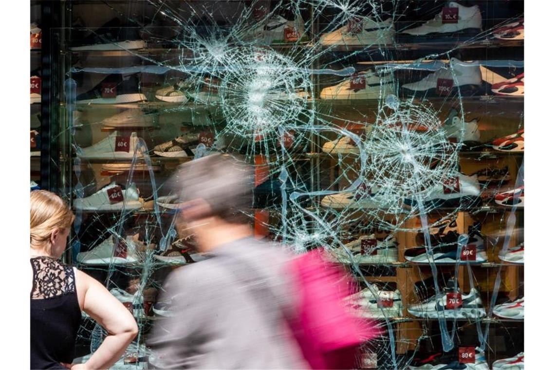 Fußgänger gehen an einem schwer beschädigten Schaufenster in der Königstrasse vorbei. Foto: Christoph Schmidt/dpa/Archivbild