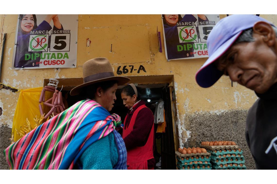 Fußgänger gehen an Wahlkampfplakaten in Cuzco in Peru vor den Präsidentschaftswahlen am Wochenende vorbei.