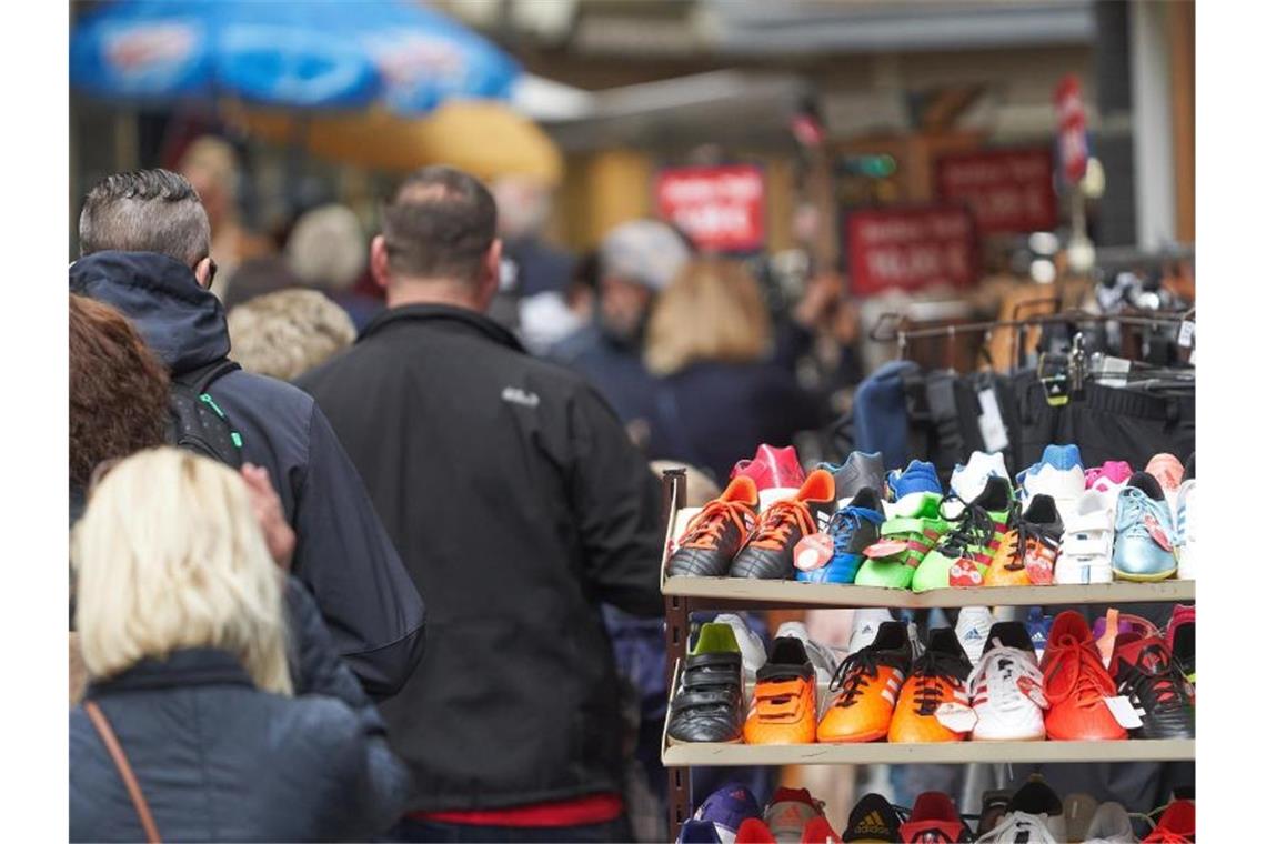 Fußgänger gehen durch die Stadt an geöffneten Läden vorbei. Foto: Thomas Frey/dpa/Symbolbild