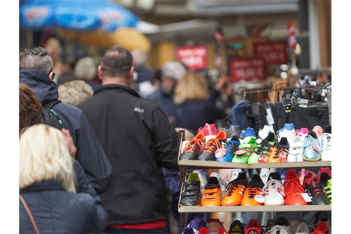 Fußgänger gehen durch die Stadt an geöffneten Läden vorbei. Foto: Thomas Frey/dpa/Symbolbild