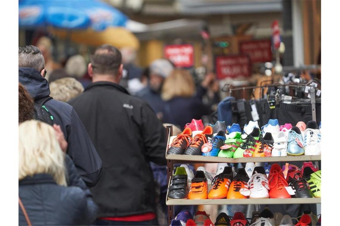 Fußgänger gehen durch die Stadt an geöffneten Läden vorbei. Foto: Thomas Frey/dpa/Symbolbild