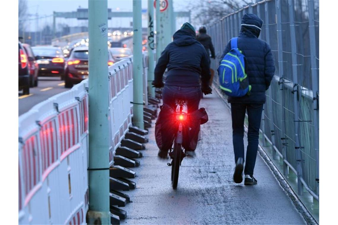 Fußgänger und Radfahre teilen sich einen schmalen Weg. Foto: Henning Kaiser/dpa/Archivbild