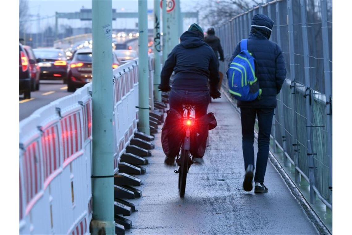 Radfahrer und Fußgänger sollen sich besser vertragen Fußgänger und Radfahre teilen sich einen schmalen Weg. Foto: Henning Kaiser/dpa/Archivbild