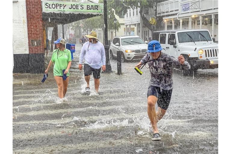Fußgänger waten durch das Hochwasser in Key West in Florida. Foto: Rob O'neal/The Key West Citizen/AP/dpa