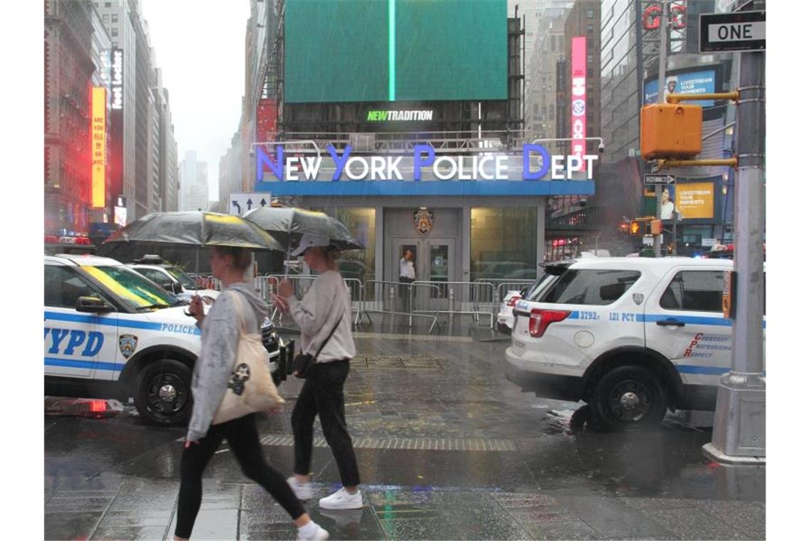 Fußgängerinnen mit Regenschirmen am Times Square in New York. Foto: Niyi Fote/TheNEWS2 via ZUMA Press Wire/dpa