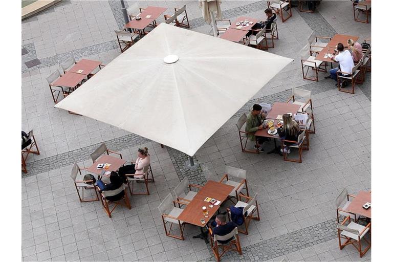 Gäste auf einer Außenterrasse in der Magdeburger Innenstadt. Laut einer Dehoga-Umfrage wissen viele Restaurant- und Café-Besucher nicht ausreichend über Abstands- und Hygieneregeln Bescheid. Foto: Ronny Hartmann/dpa