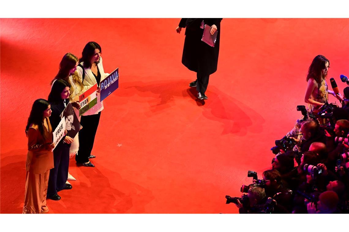 Gäste, darunter die deutsch-iranische Schauspielerin Jasmin Tabatabai (2. v. l.), halten Protestschilder hoch.