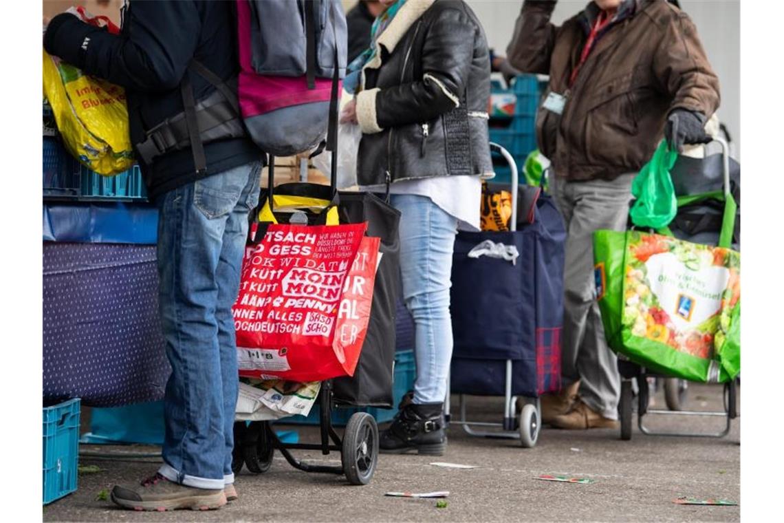 Bericht: Kaum Entkommen aus der Armut in Deutschland Gäste der Münchner Tafel stehen an der Ausgabestelle am Großmarkt. Foto: Sven Hoppe/dpa