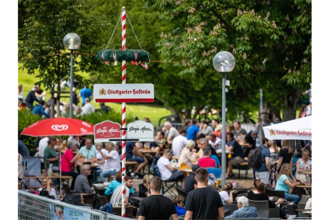 Gäste genießen in einem Biergarten im Schlossgarten das schöne Wetter. Foto: Christoph Schmidt/dpa/Archivbild