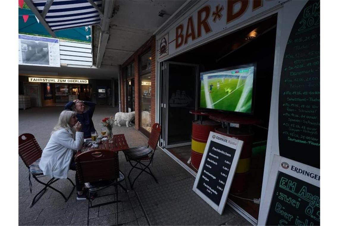 Gäste sehen im Unterland auf Helgoland in der Bar „Sailor‘s“ das EM-Spiel Frankreich gegen Deutschland . Foto: Marcus Brandt/dpa