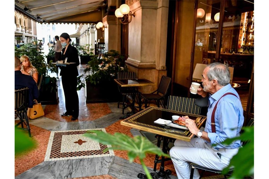 Gäste sitzen mit Abstand zueinander an Tischen in einem Café in Mailand. Foto: Claudio Furlan/LaPresse via ZUMA Press/dpa