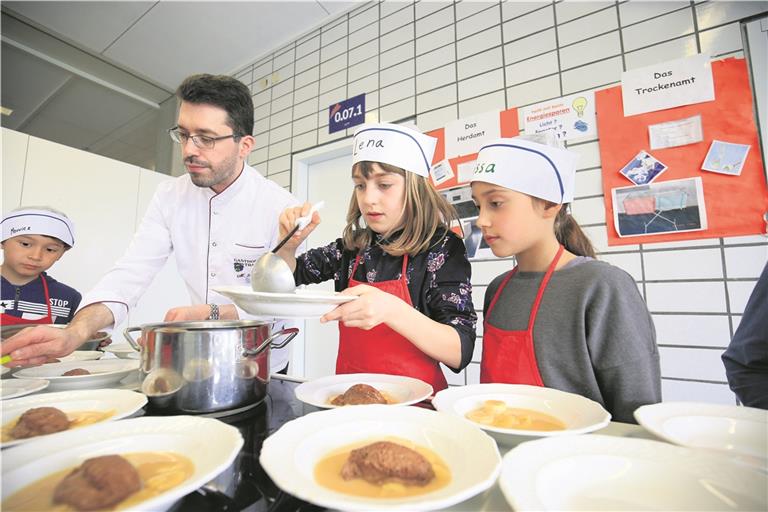 Ganz vorsichtig, dann geht auch nichts daneben: Zum Nachtisch gibt es Mousse au Chocolat mit Fruchtspiegel. Markus Binder vom Aspacher Gasthof Traube steht den Schülern mit Rat und Tat zur Seite. Foto: A. Becher