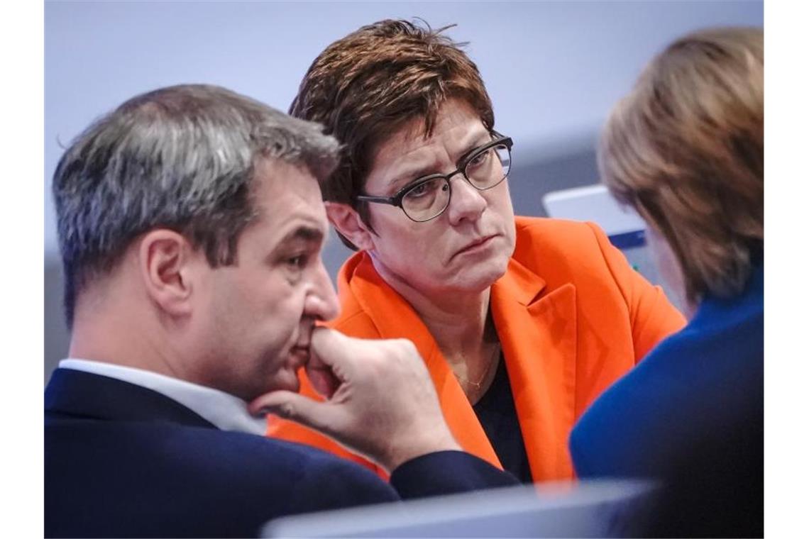 Nach CDU-Parteitag: Das sind die Aussichten für die Groko Gast Markus Söder, Annegret Kramp-Karrenbauer und Angela Merkel beraten sich beim CDU-Parteitag in Leipzig. Foto: Michael Kappeler/dpa