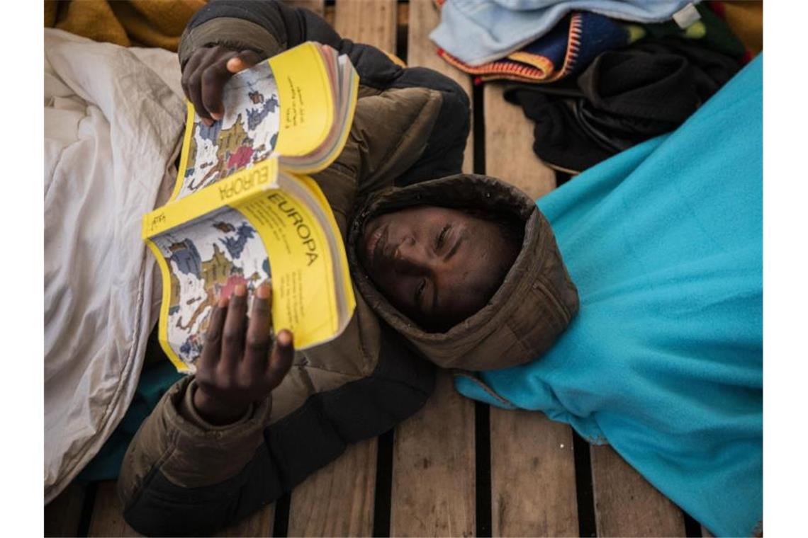 Gauro, 15, aus Mali, liest an Bord des Rettungsschiffes Open Arms ein Buch über Europa. Foto: Santi Palacios/AP/dpa
