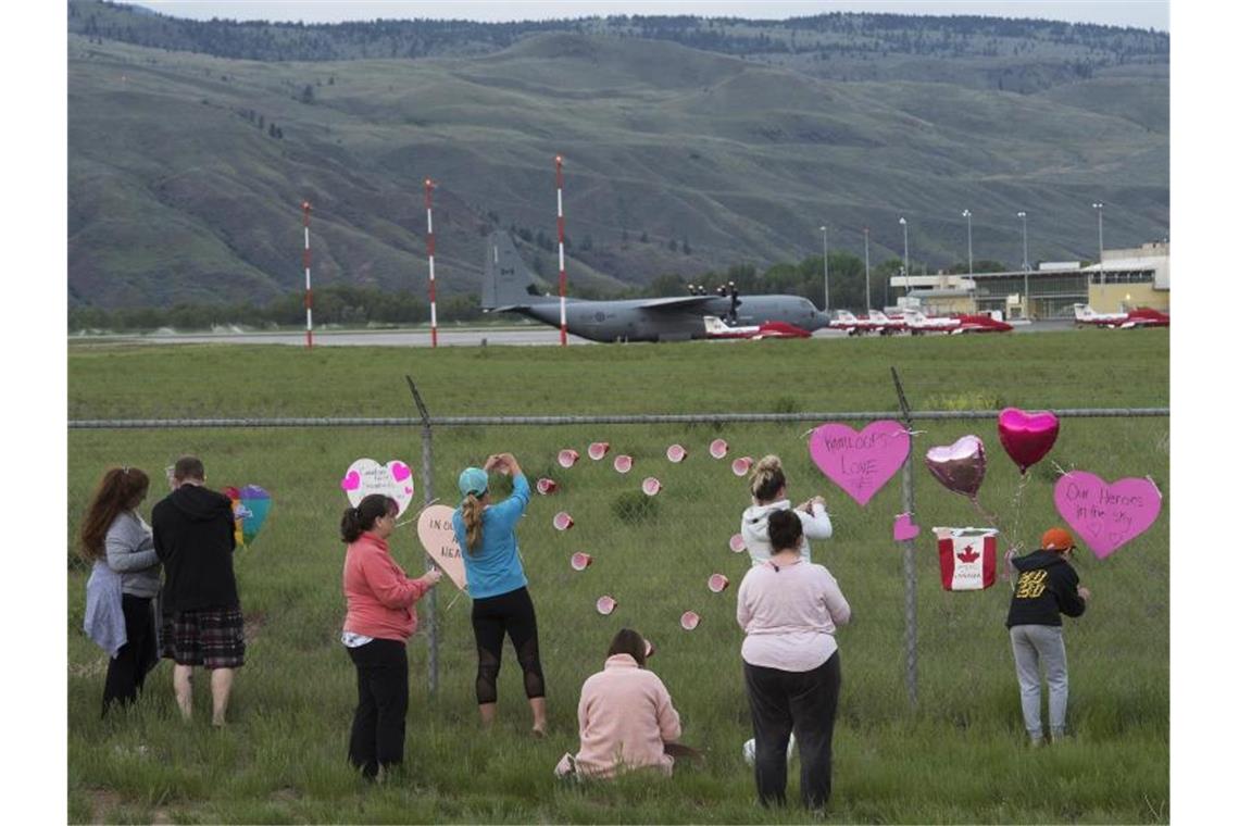 Ein Toter bei Absturz von Jet der kanadischen Air Force Gedenken am Zaun - im Hintergrund sind Flugzeuge der kanadischen Kunstflugstaffel „Snowbirds“ zu sehen. Foto: Jonathan Hayward/The Canadian Press/AP/dpa