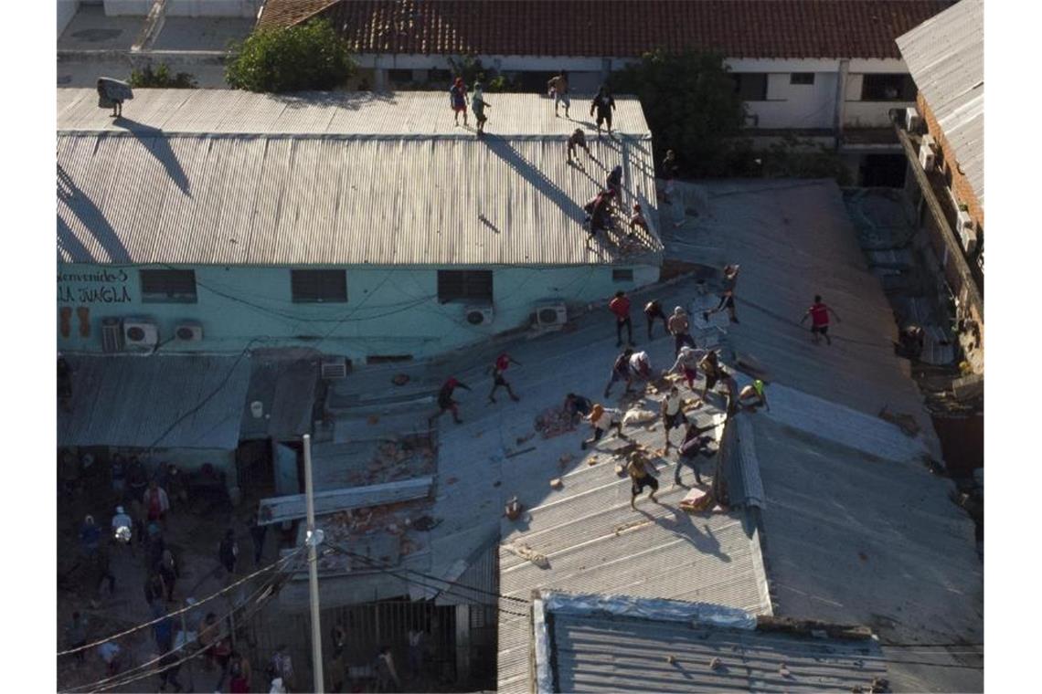Sieben Tote bei Gefangenenmeuterei in Paraguay Gefangene auf dem Dach des Tacumbú-Gefängnisses. Foto: Jorge Saenz/AP/dpa