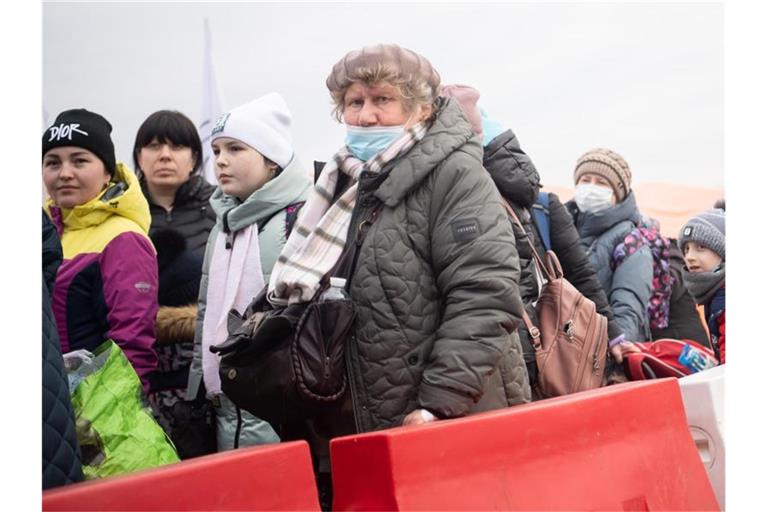 Geflüchtete aus der Ukraine stehen kurz hinter dem Grenzübergang Medyka für einen Bus an. Foto: Sebastian Gollnow/dpa