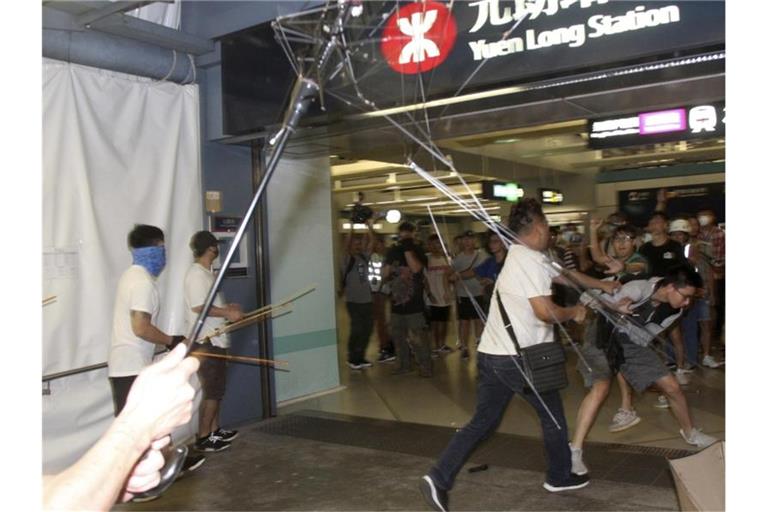 Gegen diese Übergriffe vom vergangenen Wochenende will die Protestbewegung in Hongkong demonstrieren: Männer in weißen Hemden, bewaffnet mit Metallstangen und Holzknüppeln, greifen regierungskritische Demonstranten an. Foto: Apple Daily/AP
