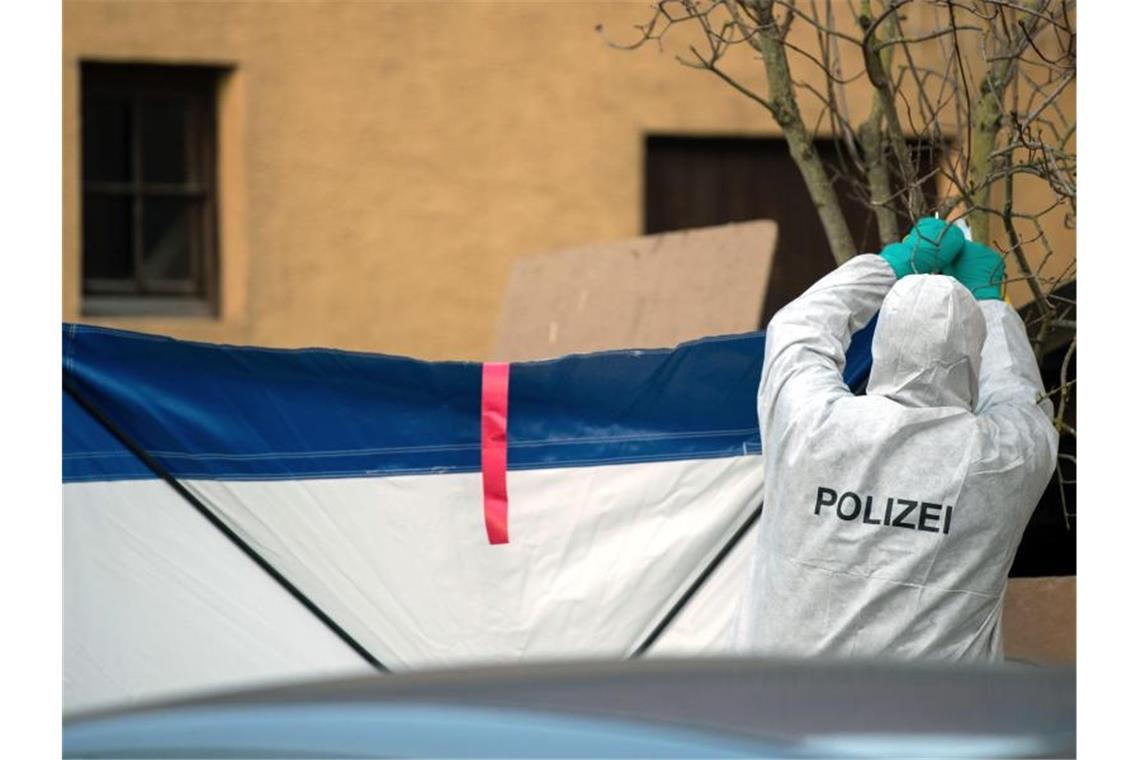 Zwei Verbrechen mit sieben Toten - Suche nach Motiven Gegen Gaffer: Nach den Schüssen in Rot am See befestigt ein Mitarbeiter der Spurensicherung einen Sichtschutz. Foto: Sebastian Gollnow/dpa