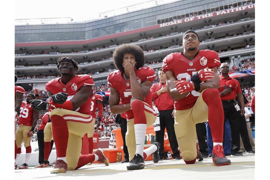 Gegen Rassismus und Polizeigewalt: Colin Kaepernick (M) kniet mit Teamkollegen während der Nationalhymne vor einem NFL-Spiel. Foto: Marcio Jose Sanchez/AP/dpa