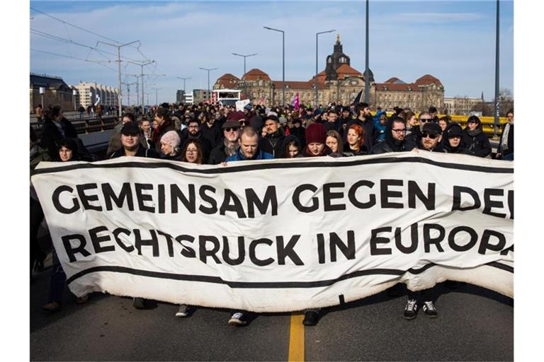 Gegendemonstranten ziehen mit einem Banner durch Dresden. Foto: Oliver Killig/dpa-Zentralbild/dpa