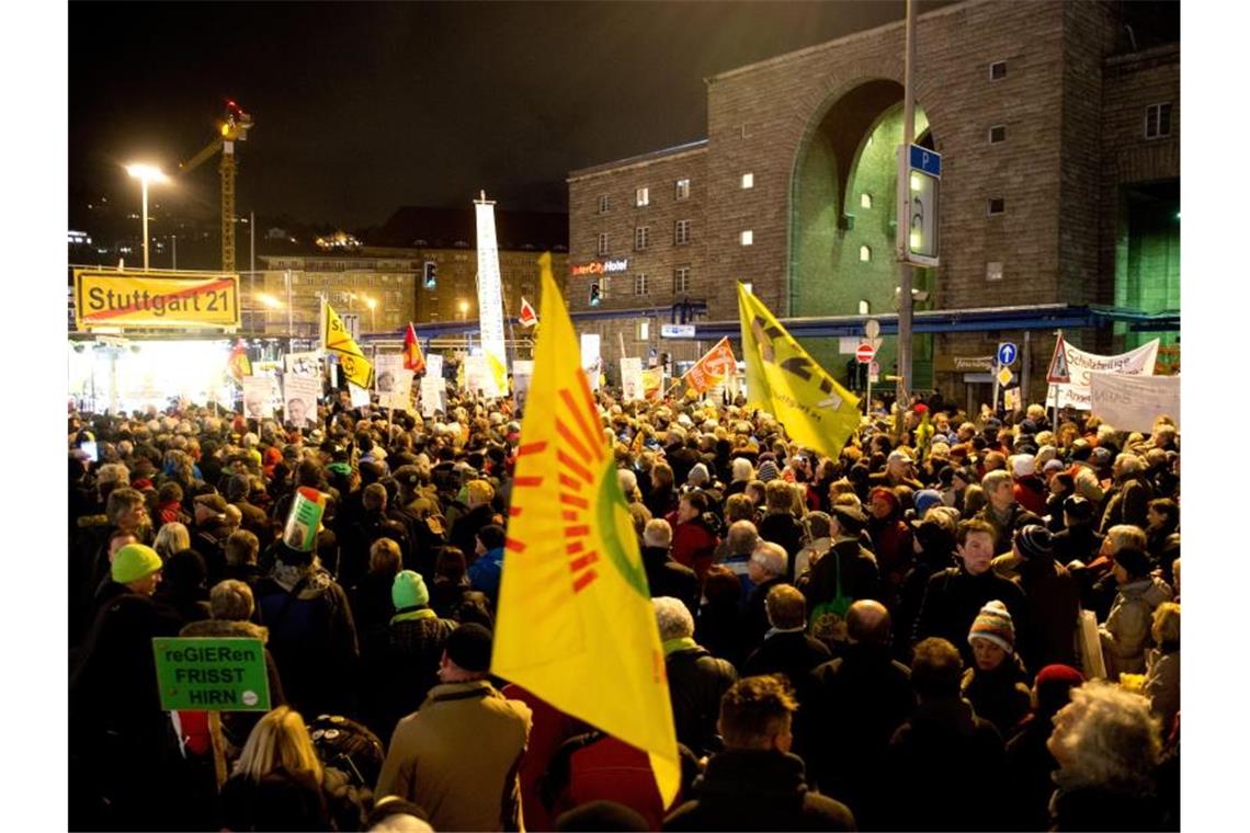 Gegner des Bahnprojektes Stuttgart 21 stehen während einer Montags-Demo vor dem Stuttgarter Hauptbahnhof. Foto: Sebastian Kahnert/dpa