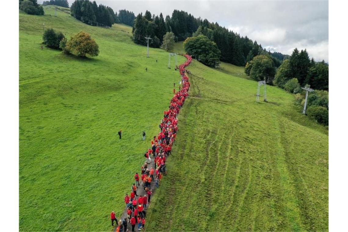 Gegner des Seilbahnprojekts am Grünten im Allgäu bilden eine Menschenkette. Foto: Karl-Josef Hildenbrand/dpa/Archivbild