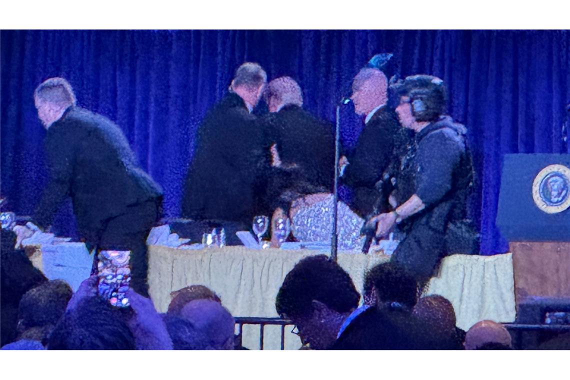 Geheimdienstmitarbeiter bringen US-Präsident Trump nach den Geräuschen von Schüssen während des White House Correspondents Dinner von der Bühne.